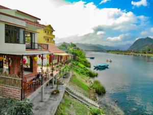峰牙Phong Nha Coco Riverside的一群靠河岸的建筑物,有船