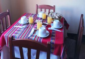 a table with a red and white table cloth and candles at Scheler Artizon Trek`s House in Huaraz