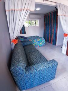 a blue couch in a room with a bed at Tropical Studio Apartment in Palm-Eagle Beach