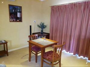 a dining room with a wooden table and two chairs at Murrayview Guest House in Tailem Bend