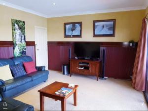 a living room with a couch and a tv at Murrayview Guest House in Tailem Bend