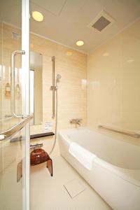 a bathroom with a white tub and a shower at Smart Condo Tomari in Naha