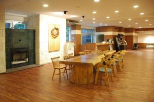 a large wooden table and chairs in a room with a fireplace at Onsen Yupopo in Senboku