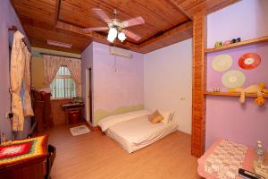 Schlafzimmer mit einem Bett und einem Deckenventilator in der Unterkunft DOWN HWA NO.8 in Pinghe