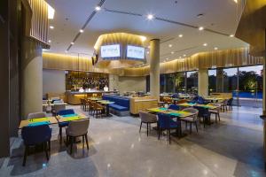 a restaurant with tables and chairs and a bar at Modena by Fraser Buriram in Buriram