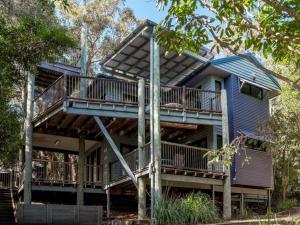 a large blue house with a deck and stairs at Billa Blue in Point Lookout