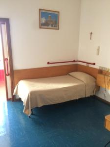 a bedroom with a bed and a cross on the wall at Casa per ferie Al Centro in Belluno