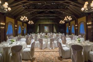 a banquet hall with white tables and chairs and chandeliers at Fairmont Le Chateau Montebello in Montebello +126 photos