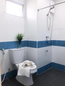 La salle de bains est pourvue d'une douche et de toilettes. dans l'établissement โรงแรม เดอะริช ราชพฤกษ์ โฮเทล แอนด์ เรสซิเดนซ์, à Nonthaburi