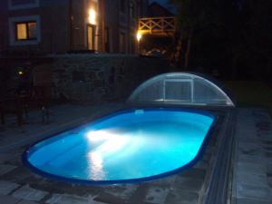 a blue swimming pool in a yard at night at Penzión Terra Banensium in Banská Štiavnica