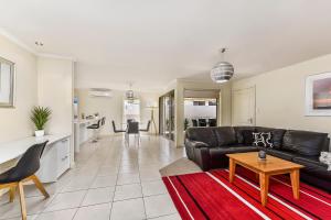 a living room with a black leather couch and a table at City Fringe Apartment in Mount Gambier