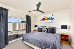 a bedroom with a bed and a large window at City Fringe Apartment in Mount Gambier