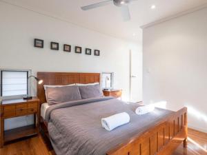 a bedroom with a large bed with two towels on it at Stradbroke Sunset in Point Lookout