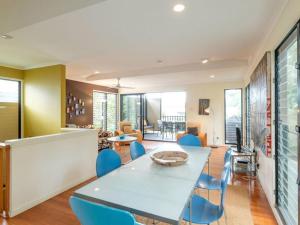 Un comedor con una mesa y sillas azules. en Straddie Beach House 2 by Discover Stradbroke, en Point Lookout 9 fotos más