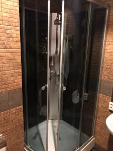 a glass shower in a bathroom with a sink at Apartment Chalet in Shakhty