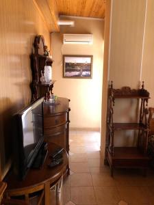 a living room with a tv on a wooden table at Apartment Chalet in Shakhty