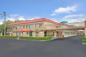 a large building with a parking lot in front of it at Days Inn by Wyndham Clearwater/Central in Clearwater