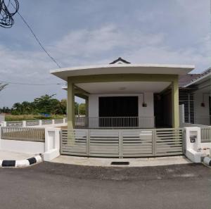 dom z białym płotem przed nim w obiekcie AZ Homestay Bertam Perdana With Free Wifi w mieście Kepala Batas