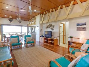 a living room with blue chairs and a television at Claytons 1 by Discover Stradbroke in Point Lookout