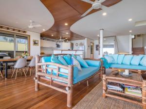 a living room with blue furniture and a kitchen at Claytons 10 in Point Lookout