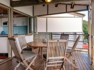 a dining room with a table and chairs on a deck at Claytons 8 by Discover Stradbroke in Point Lookout