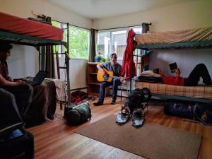Base Camp Anchorage Hostel في أنكوراج: مجموعة من الناس في غرفة مع سرير بطابقين