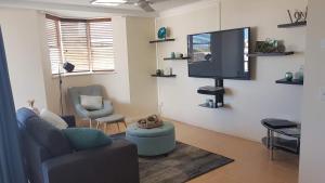 a living room with a flat screen tv on a wall at Santalina On Hervey Bay in Hervey Bay