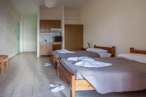 a room with two beds and a kitchen with a kitchen at Hill of Calm in Triopetra