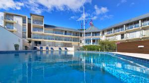 Picton Yacht Club Hotel في بيكتون: مسبح فارغ امام مبنى