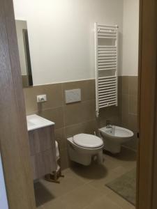 a bathroom with a toilet and a sink and a mirror at La Casetta di Mariangela in Camporosso in Valcanale