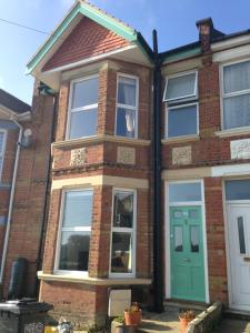 a brick house with a green door at Large Sunny King-Size En-Suite in Hastings