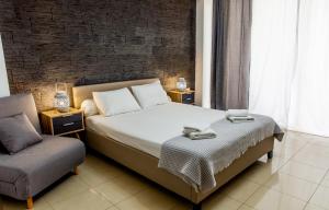 um quarto com uma cama e uma cadeira em Central Beauty em Lerápetra
