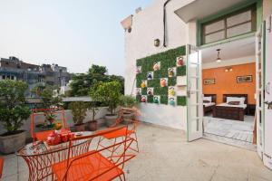 a patio with a table and chairs on a balcony at Prakash Kutir B&B in New Delhi