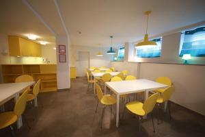 a classroom with tables and chairs and a kitchen at eMKa Hostel in Warsaw