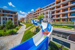 a child on a water slide in front of a building at Premier Fort Club Hotel - Full Board in Sunny Beach