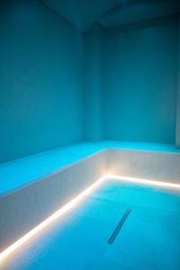 a swimming pool with blue lights in a room at MONUN Hotel&Spa in Grottaglie