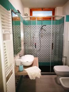 uma casa de banho com um chuveiro, um lavatório e um WC. em A casa di Vince Monteaperti em Montaperti