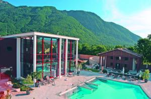 a house with a swimming pool and mountains in the background at Kurhotel Falter in Bad Reichenhall