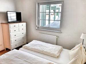ein Schlafzimmer mit einem Bett und einem TV auf einer Kommode in der Unterkunft Hubertus Dependance in Obertauern