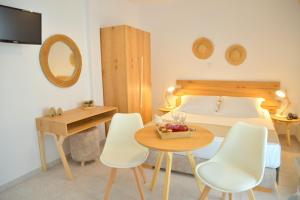 sypialnia z łóżkiem, stołem i krzesłami w obiekcie Studios Kymata w mieście Pollonia