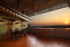a table and chairs on a balcony with a view at Hill Top Luxury Villa - 3 BHK || Infinity Pool in Mapusa