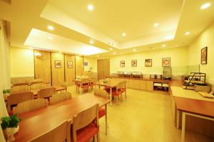 un ristorante con tavoli e sedie in legno e una cucina di Home Inn Zhengzhou Huanghe Road Provincial People's Hospital a Zhengzhou