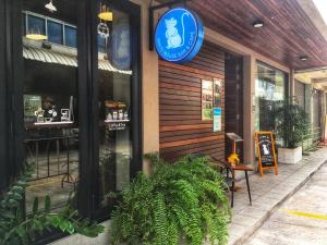 a restaurant with a blue sign on the side of a building at Chakrabongse Residences in Bangkok