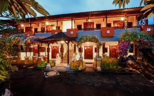 a building with flowers and plants in front of it at Bali Taman Beach Resort & Spa Lovina in Lovina