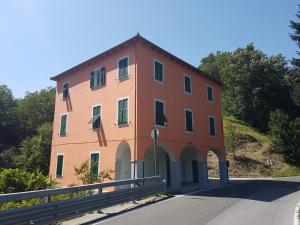 ein großes orangefarbenes Gebäude an der Seite einer Straße in der Unterkunft La Casa degli Archi in Tavarone