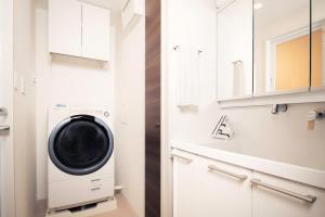 a laundry room with a washer and dryer at Oakwood Apartments Nishi-Shinjuku Tokyo in Tokyo +4 photos