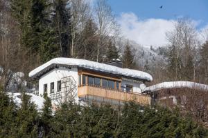 una casa con nieve encima en Ferienchalet Panoramablick, en Kössen