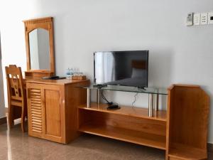 a television on a wooden entertainment center with a mirror at Huong Bien Hotel in Phan Rang