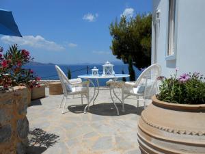 伊茲拉的住宿－HydraVista (Coral)，一个带桌椅的庭院和大海