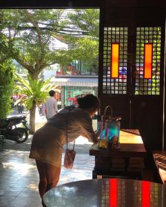 a woman standing next to a table with a bag at KARON SINO House in Karon Beach